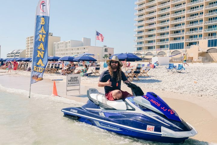 a man sitting on a jet ski on the beach